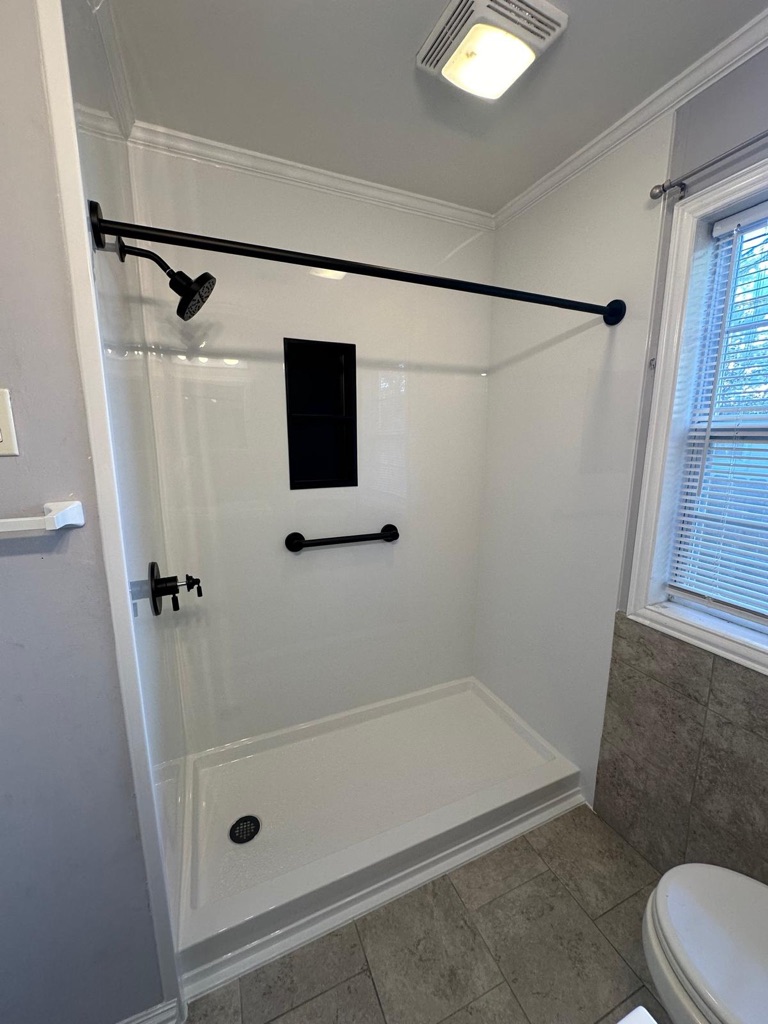 White walk in shower with matte black fixtures, a recessed niche and a grab bar