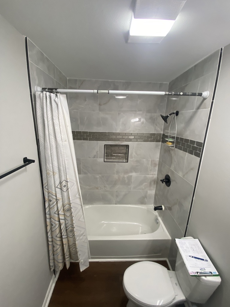 Before: an old tub and shower combination with a curtain