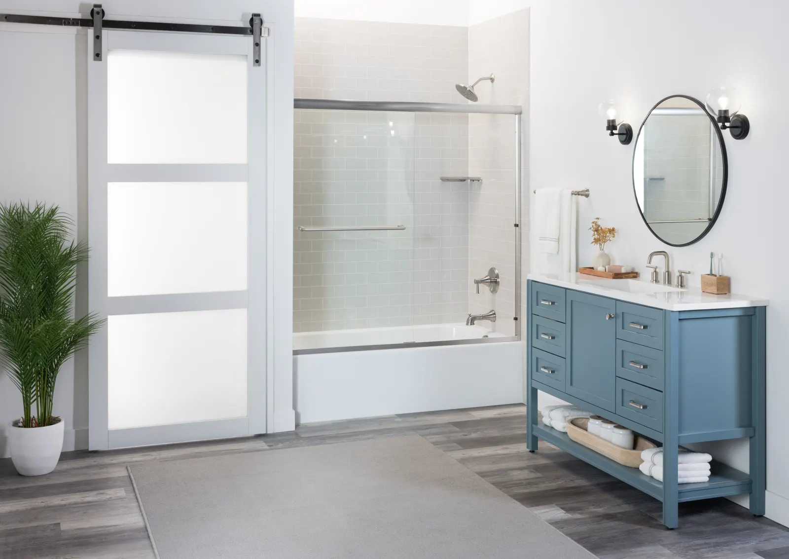 Barn door bathroom with tub and shower, blue vanity