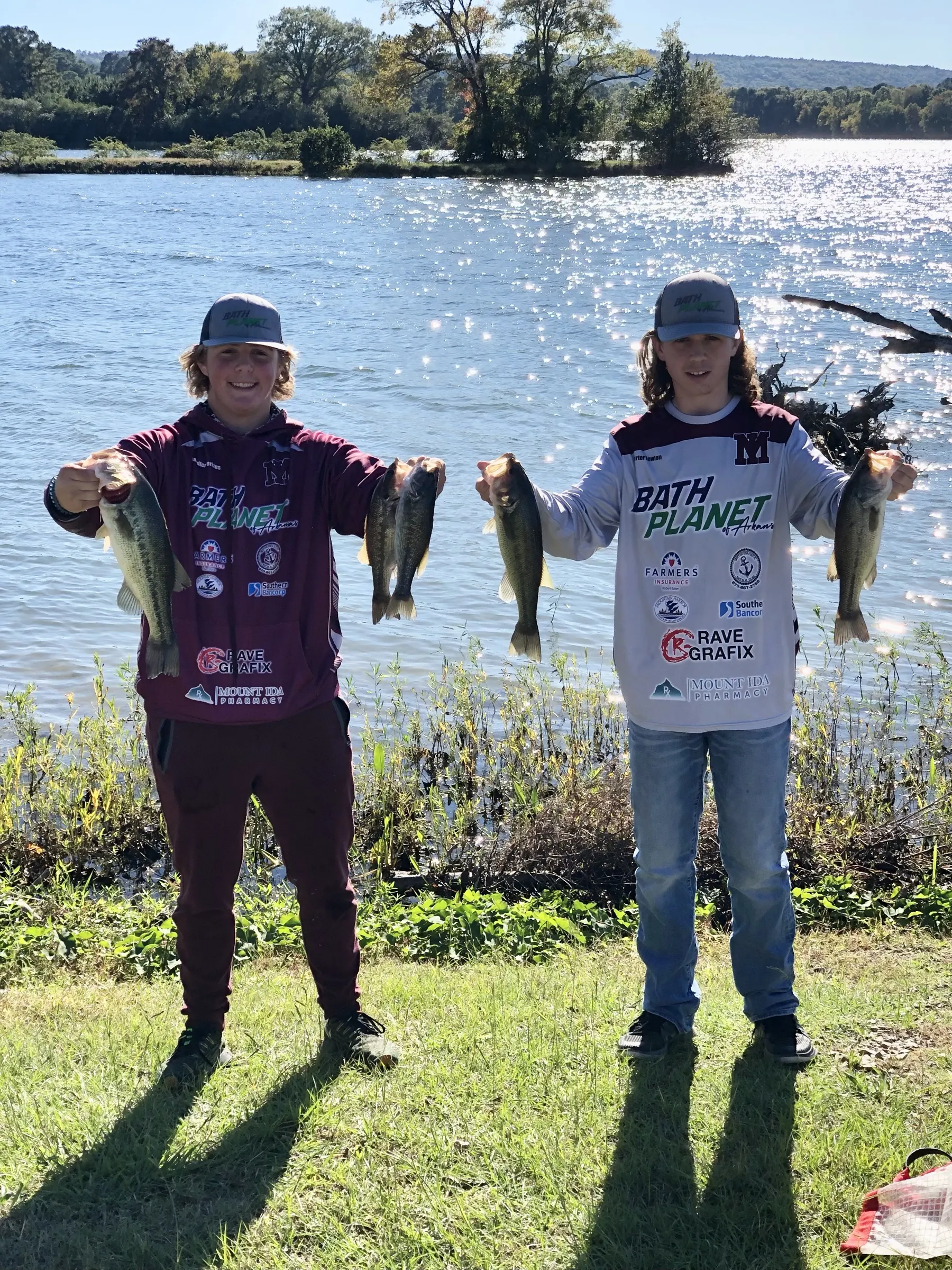Bath Planet sponsored youth anglers holding bass on the lakeshore