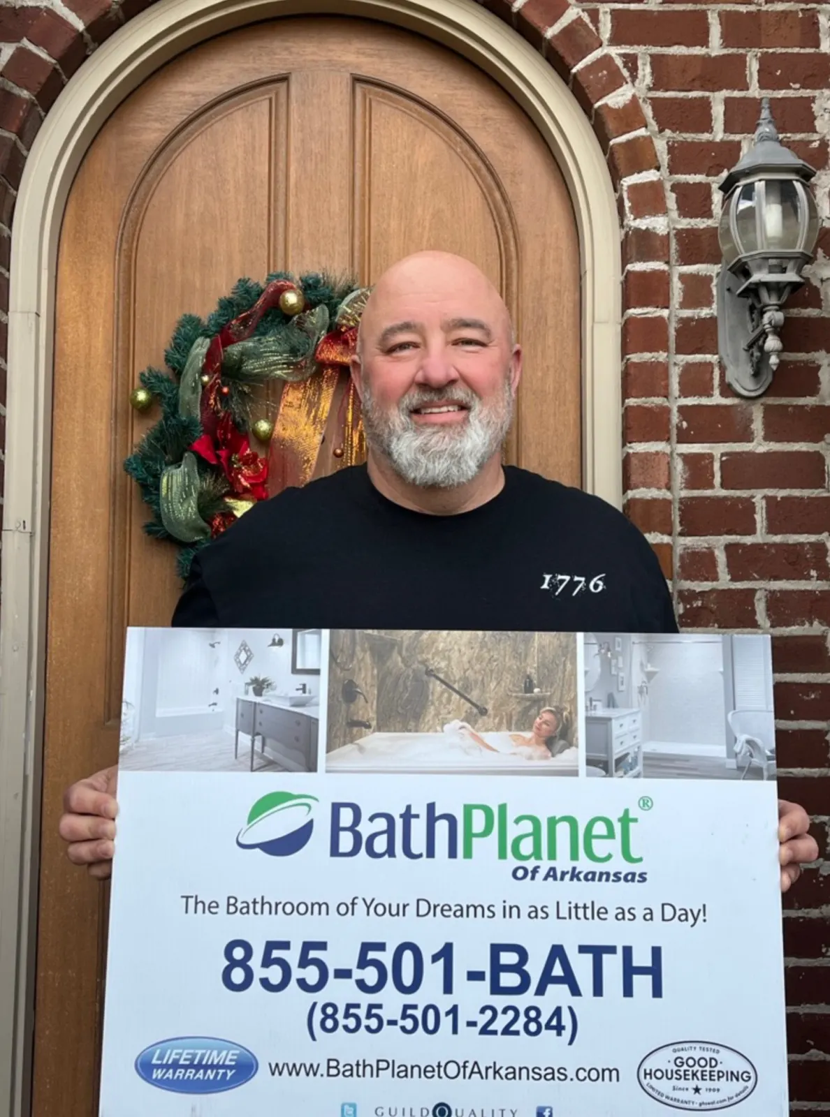 Customer in doorway holding Bath Planet 855-501 BATH sign