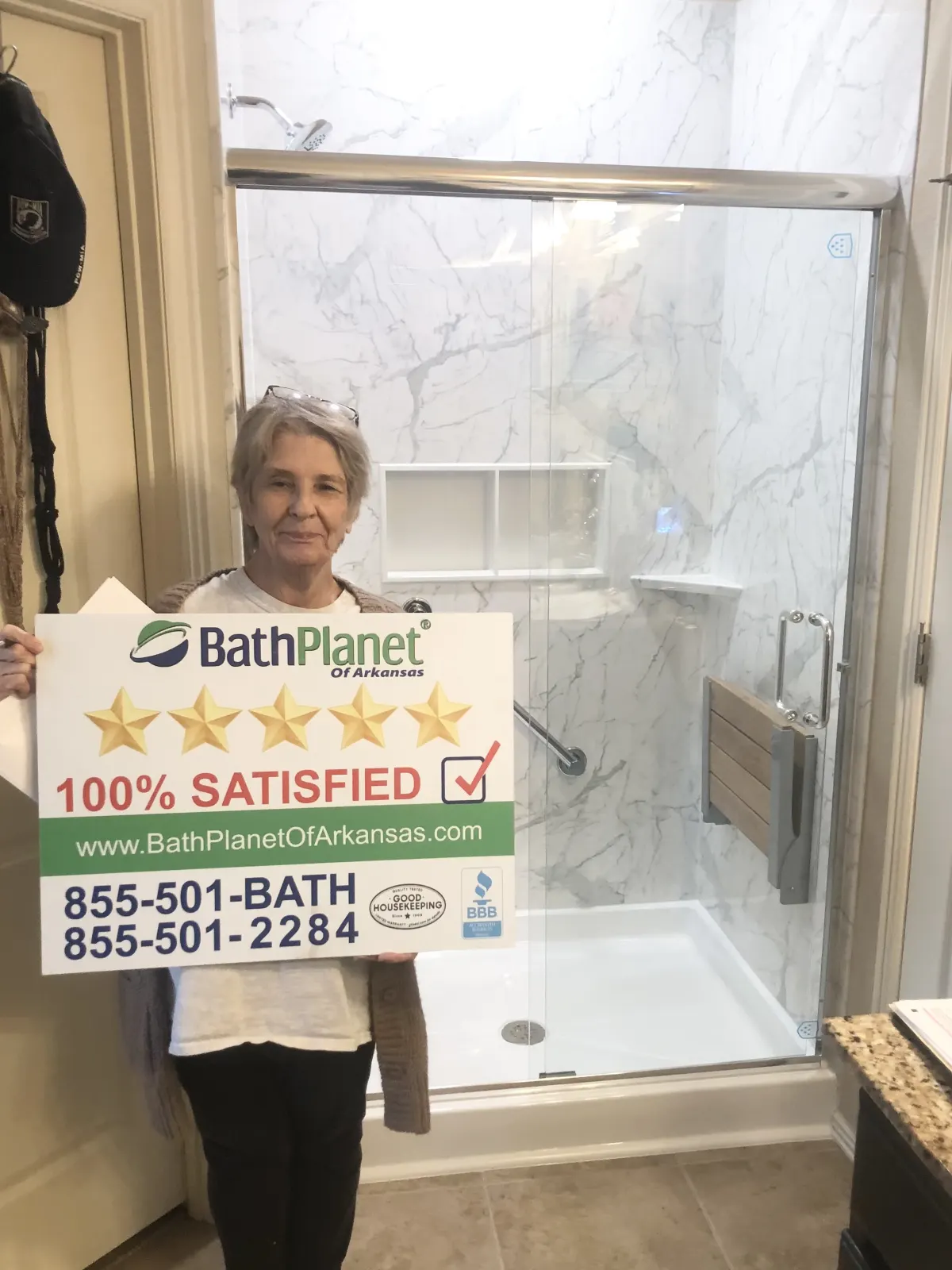 Customer in walk in shower with sign and bench