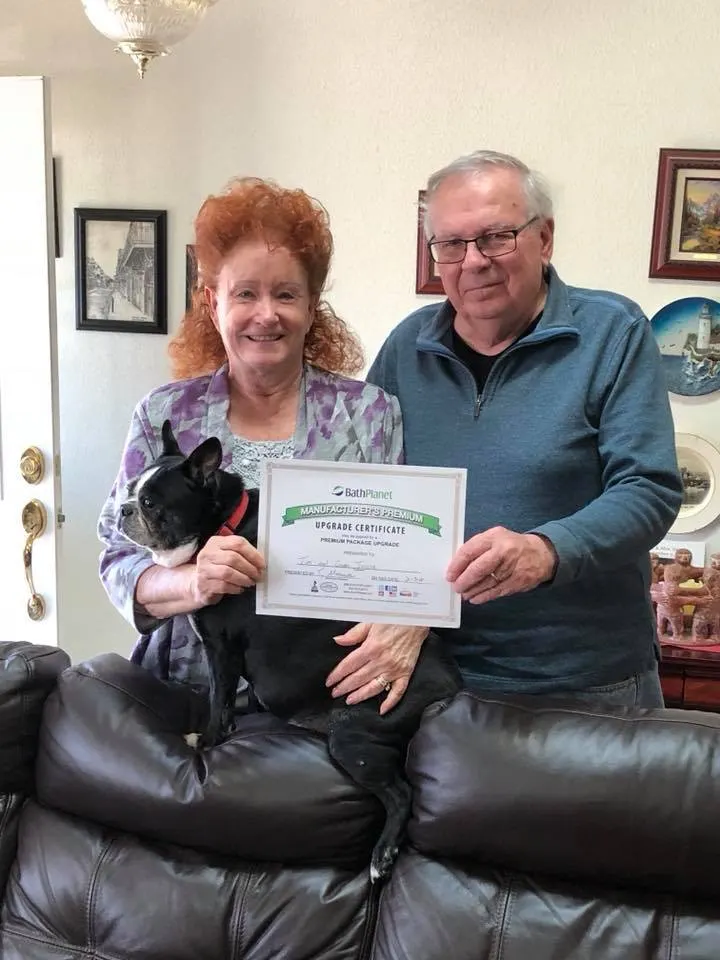 Elderly couple with small black dog holding Bath Planet certificate, Customer Feedback hero