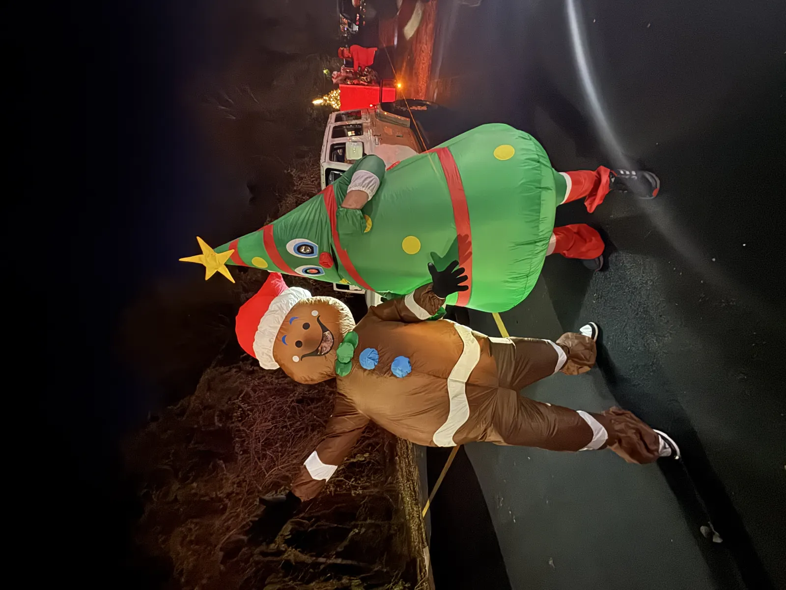 Gingerbread man and inflatable Christmas tree at night parade
