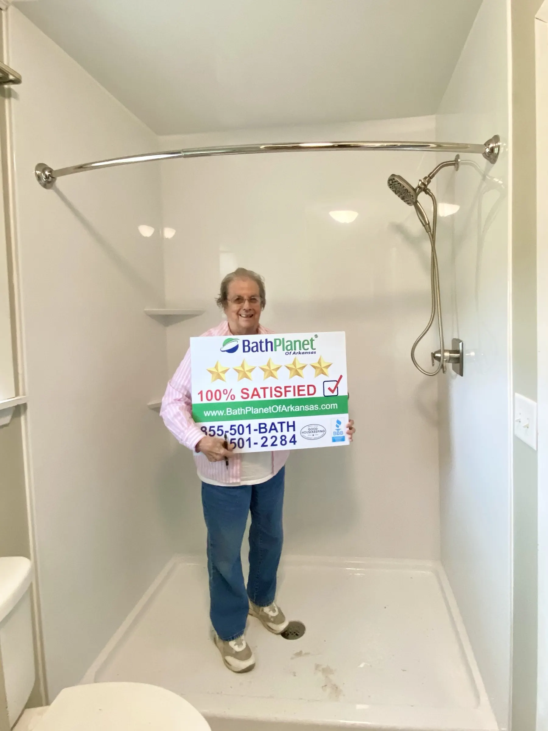 Homeowner holding a 100% Satisfied sign in her new walk in shower