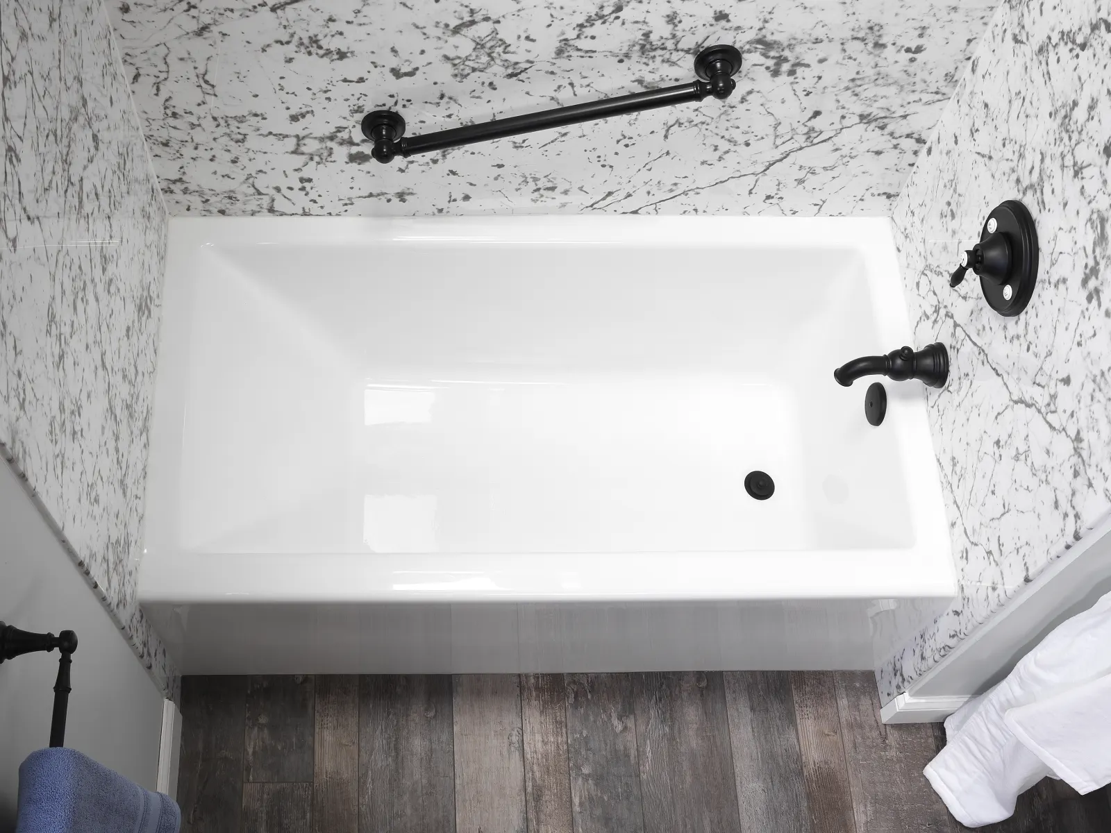 White tub with black grab bar, veined surround