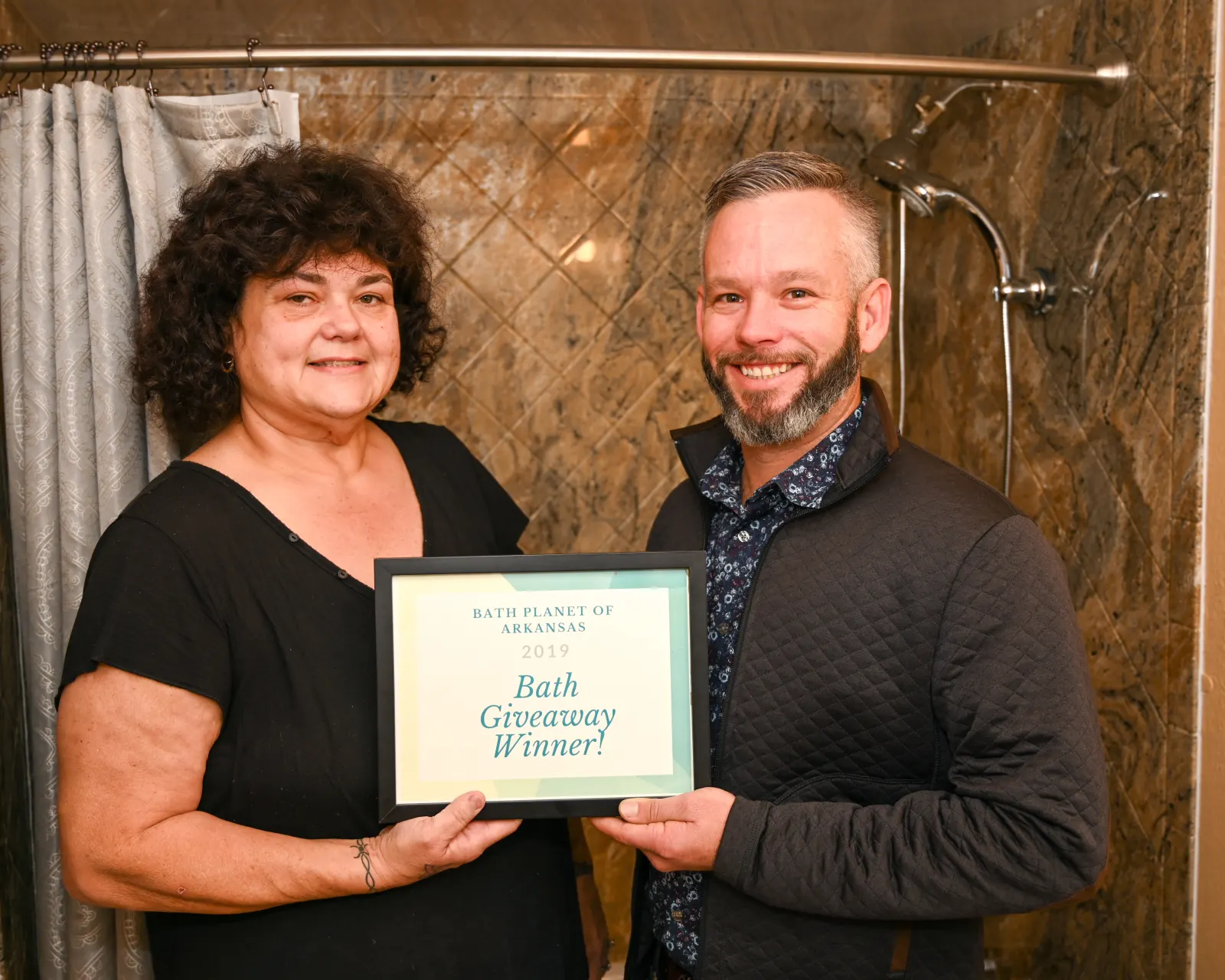 Woman and man holding Bath Giveaway Winner certificate