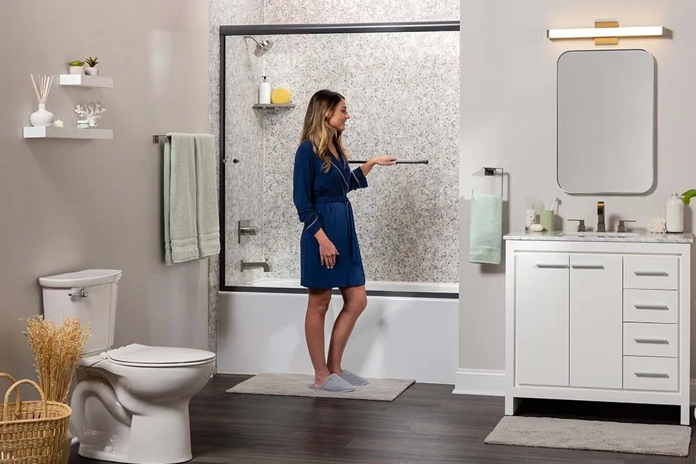 Woman gesturing in bright bathroom with marble look shower